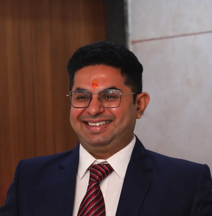 Dr. Dipen Thakkar smiling in a navy suit
