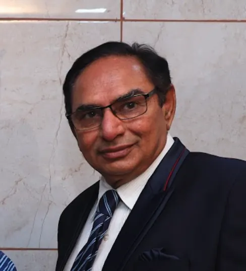 Dr. Rajendra Thakkar wearing glasses and a navy suit